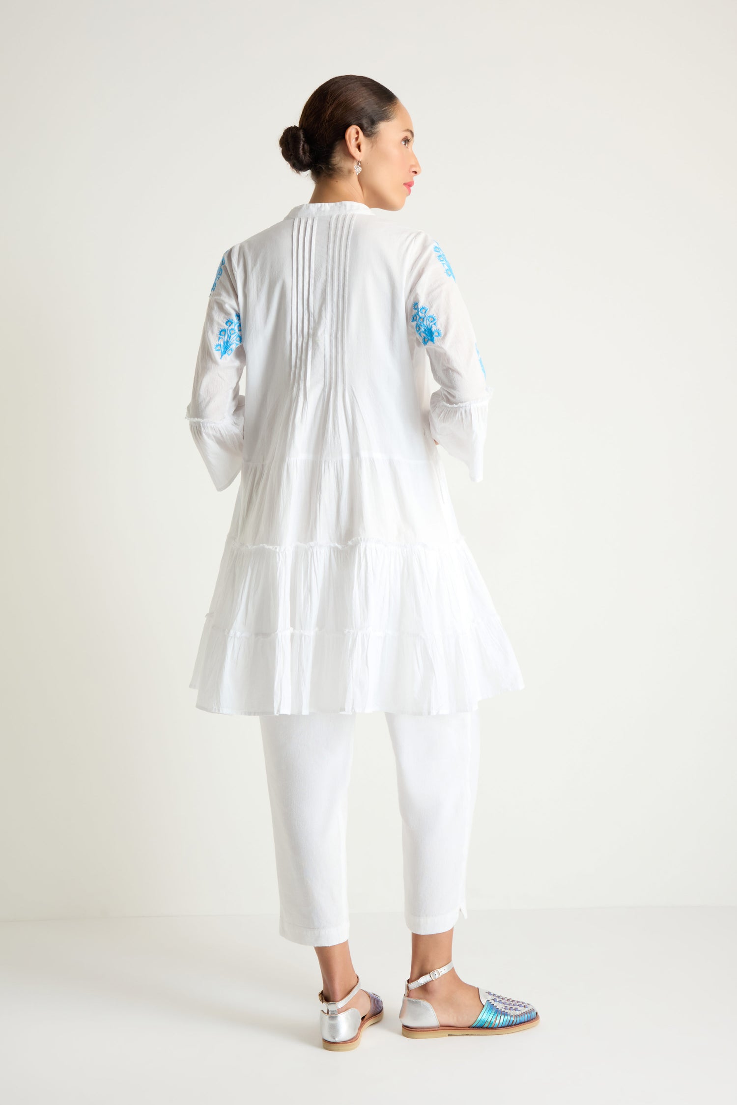 Woman showcases the Embroidered Floral Flared Sleeve Tunic, featuring pure cotton and floral embroidery, viewed from the back against a plain white background.