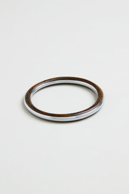 The Wooden Silver Fusion Bangle, featuring a wood-textured finish and a smooth metallic inner edge, is showcased against a plain light background.