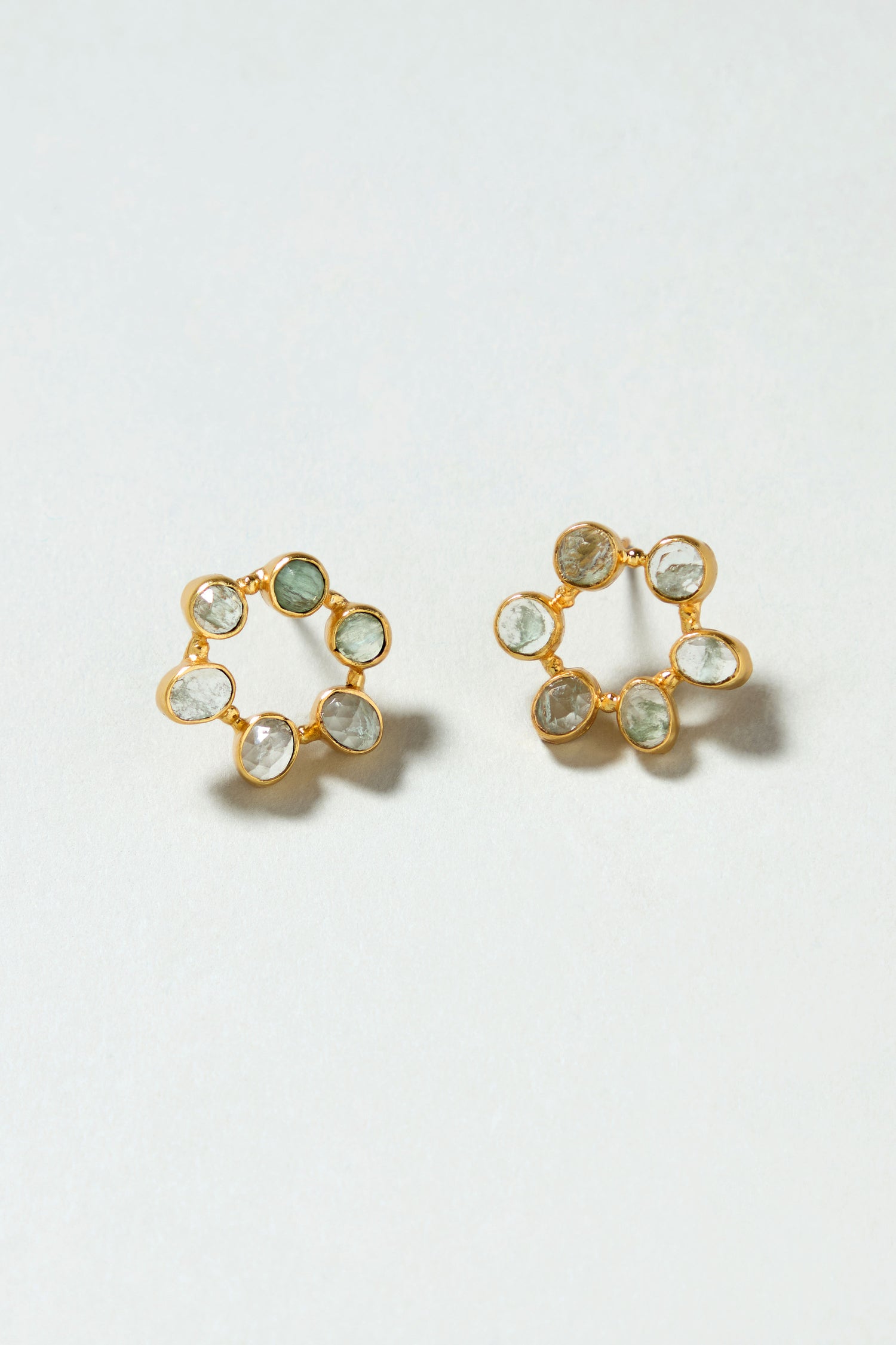 The Hand Crafted Aqua Crackle Mini Stone Earrings are gold plated and feature six small, irregular gemstones arranged in a circular pattern.