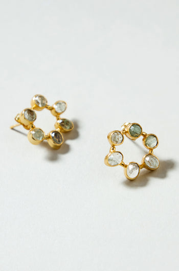 The Hand Crafted Aqua Crackle Mini Stone Earrings feature a gold-plated circular design with seven oval, transparent aqua gemstones around the edge, offering a unique handcrafted look.