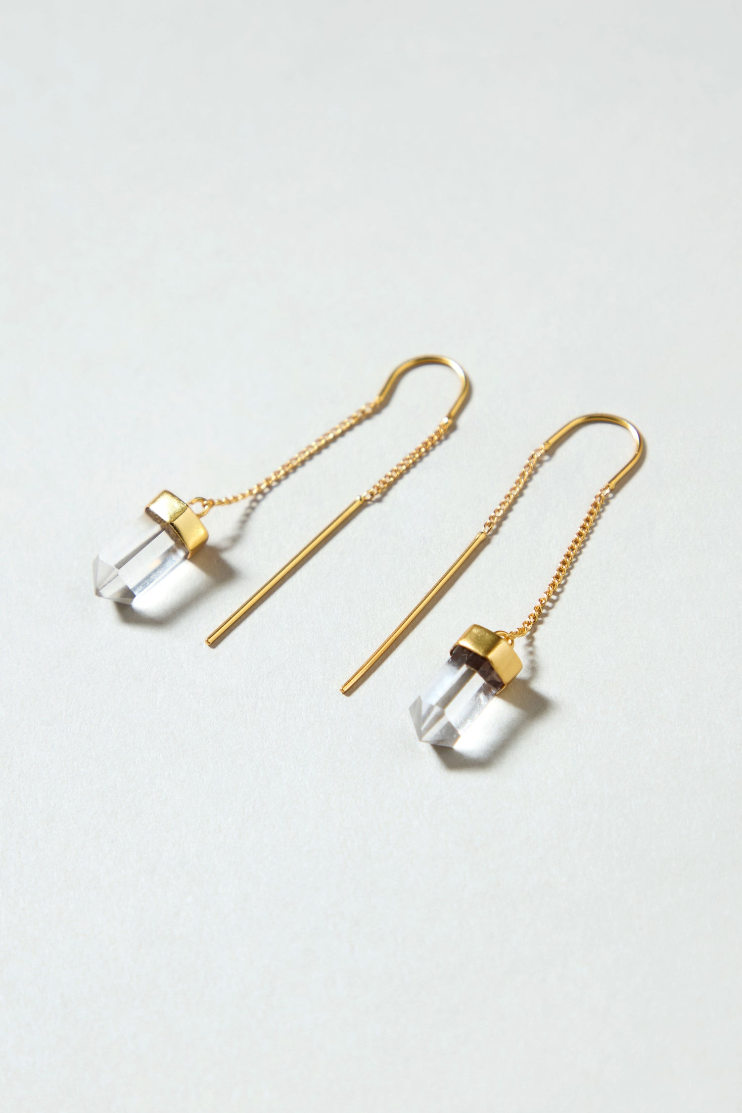 Hand Crafted Clear Quartz Crystal Drop Earrings featuring clear quartz pendants elegantly displayed on a light surface.