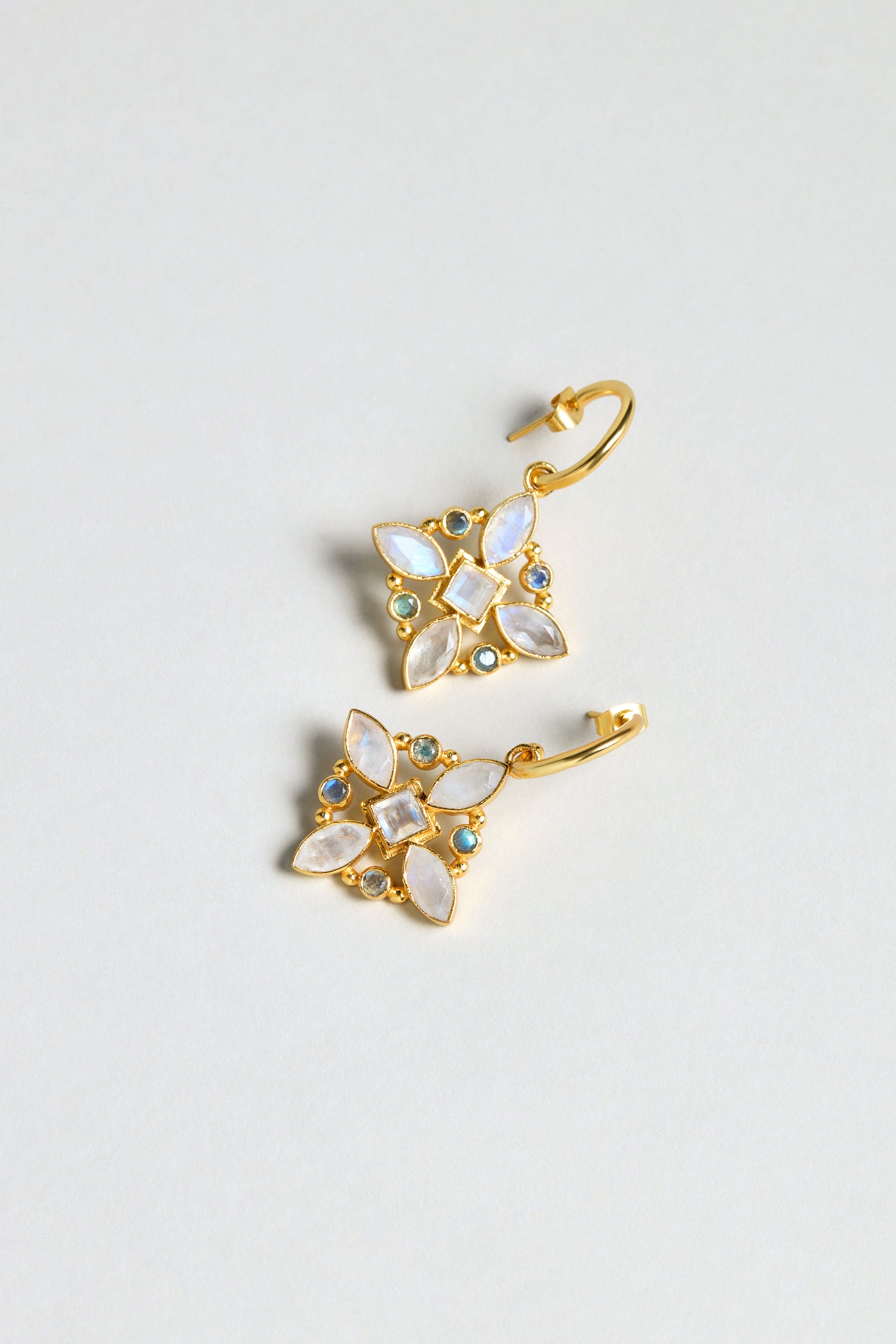 Hand Crafted Moonstone Labradorite Decorative Earrings featuring a floral design with white and blue gemstones arranged symmetrically on each gold-plated earring.