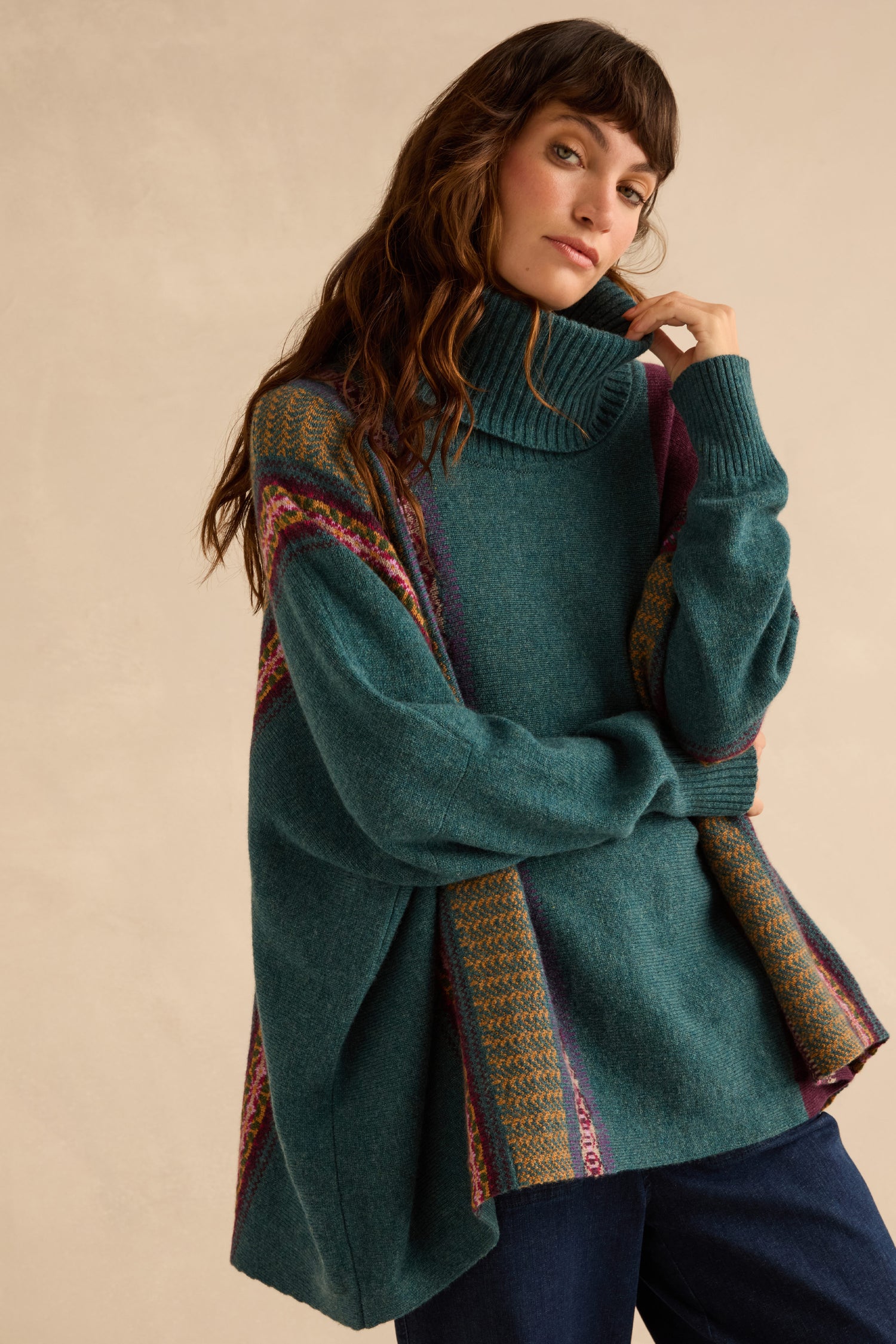A person wearing an oversized teal Hunter Montrose Cowl Neck Sweater featuring Fair Isle patterned geometric panels.