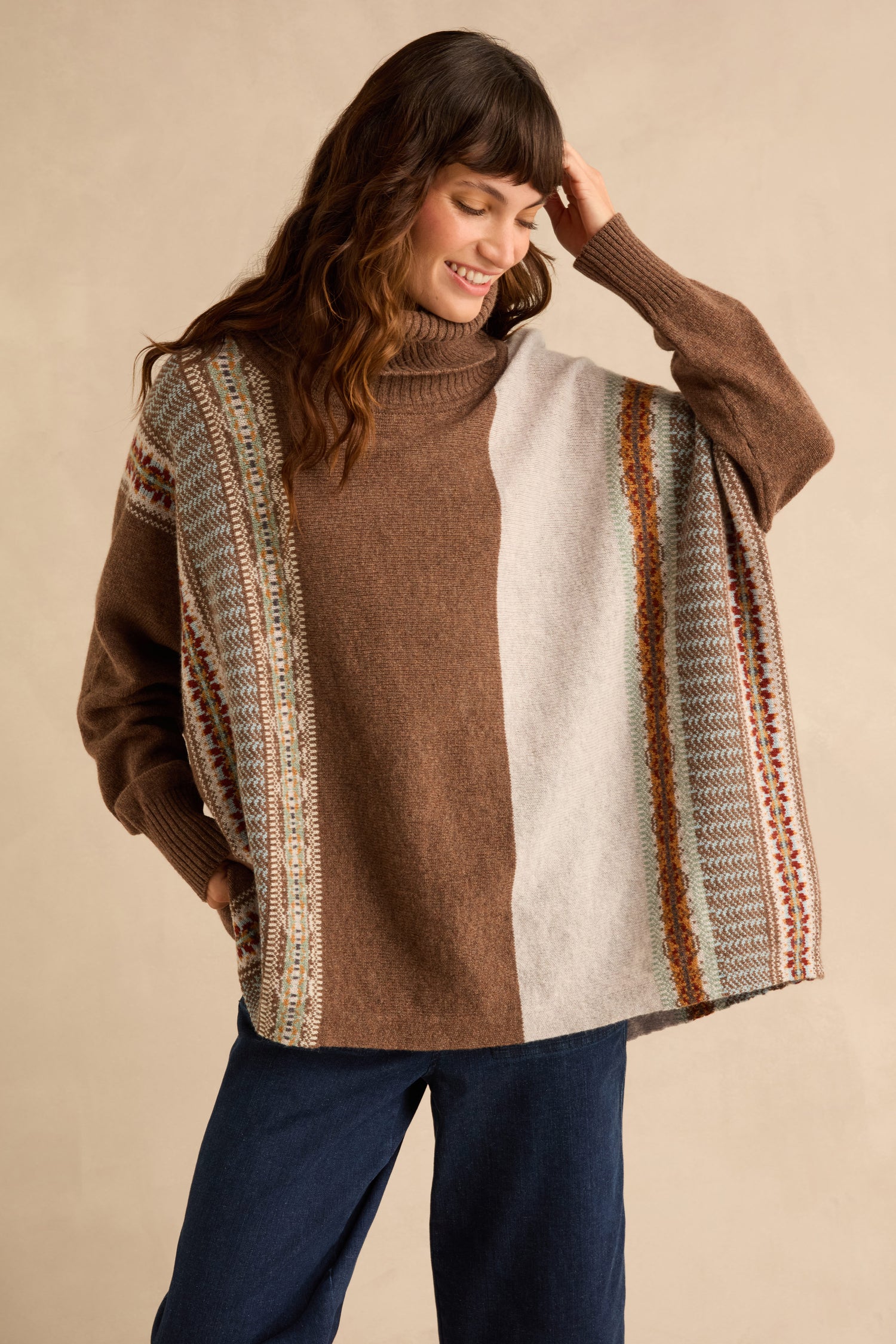 Woman wearing a Mushroom Montrose Cowl Neck Sweater featuring a brown and beige Fair Isle pattern, vertical stripes, and ribbed cuffs.
