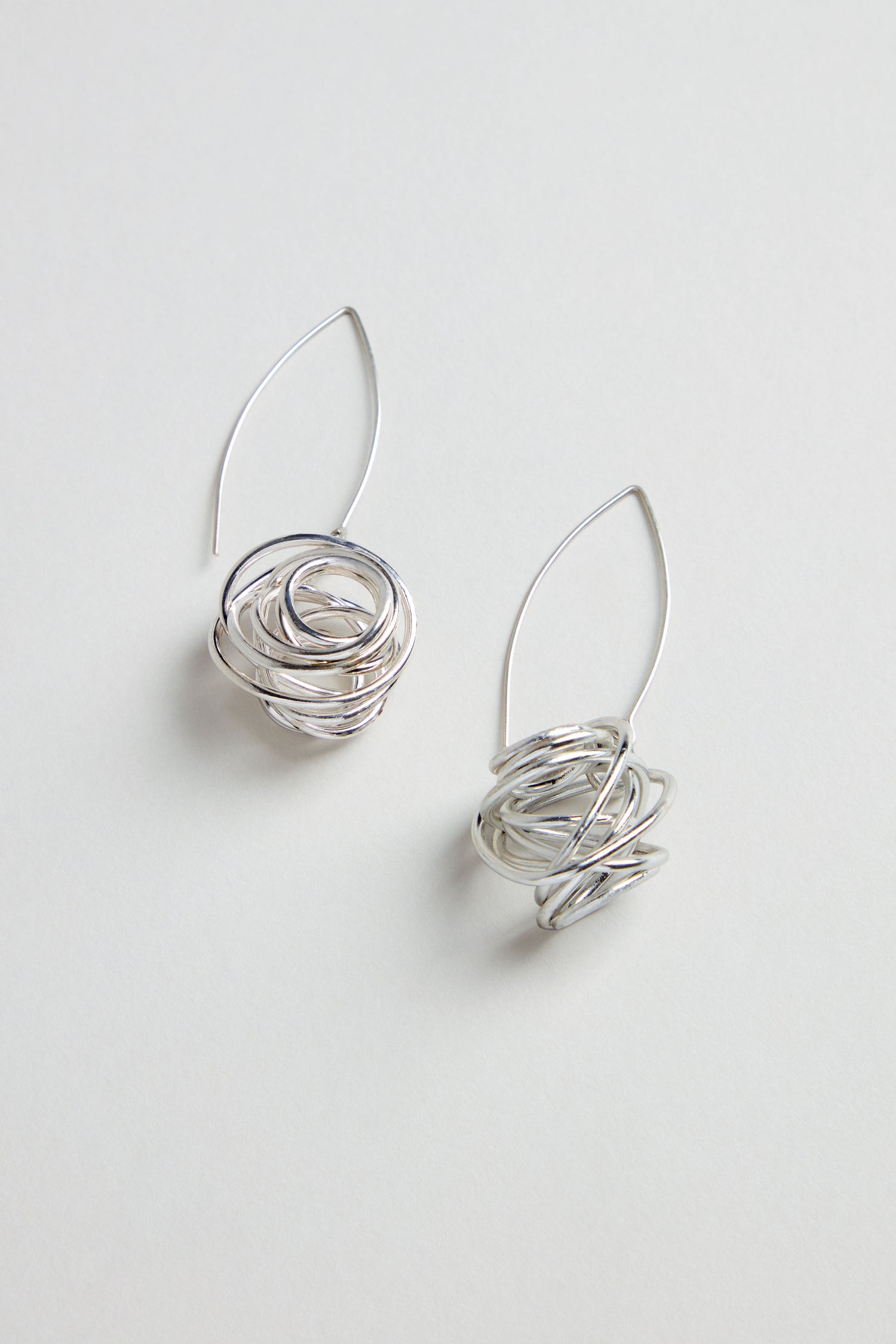 Silver Scribble Earrings—sculptural earrings featuring abstract, nest-like designs—are shown against a plain white background.