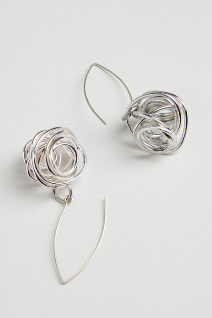 The Silver Scribble Earrings feature a unique tangled knot design with curved, thin wire hooks for a sculptural look that’s lightweight and stylish.