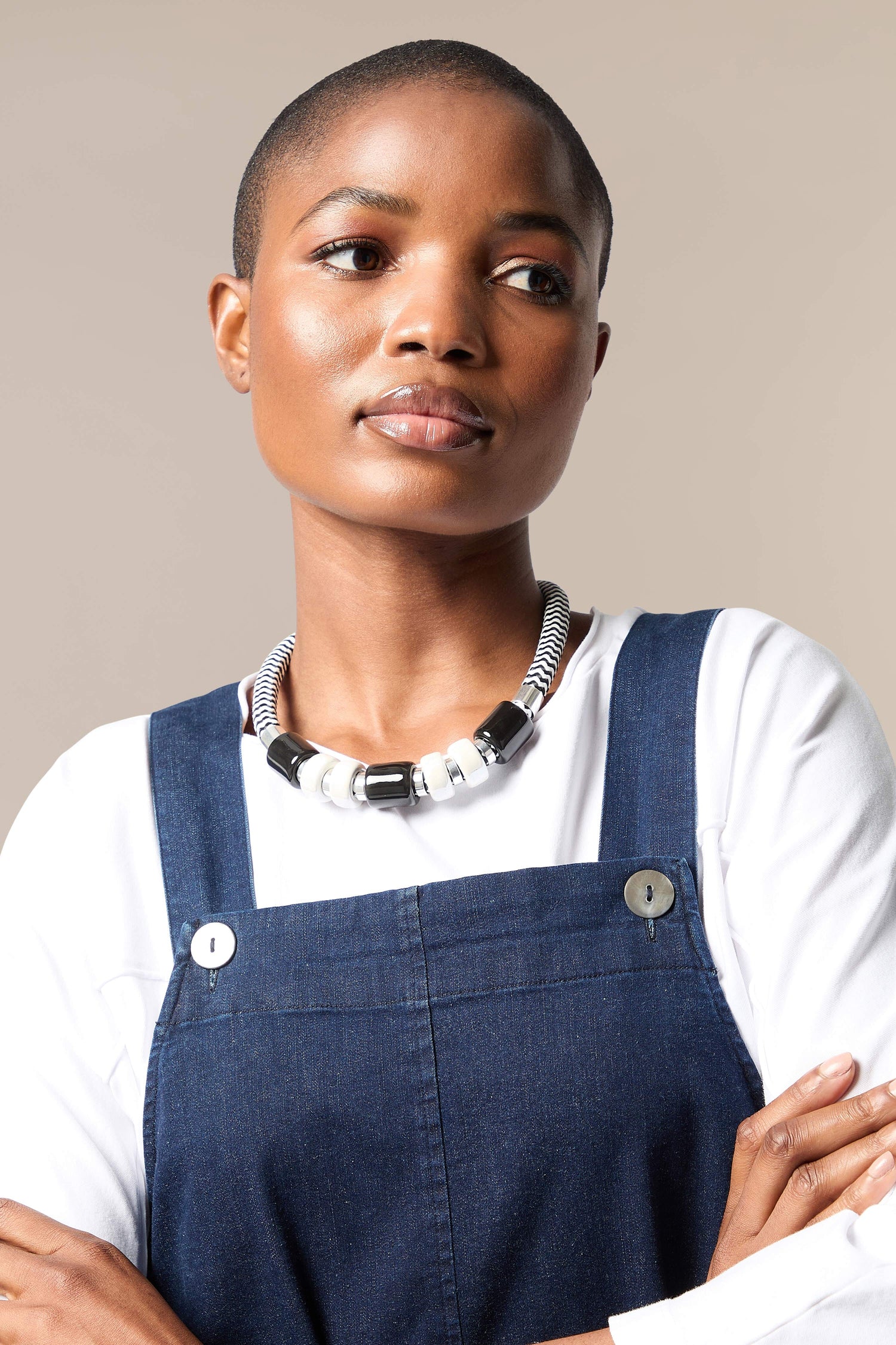 A black woman wearing overalls and a Monochrome Bead Necklace.