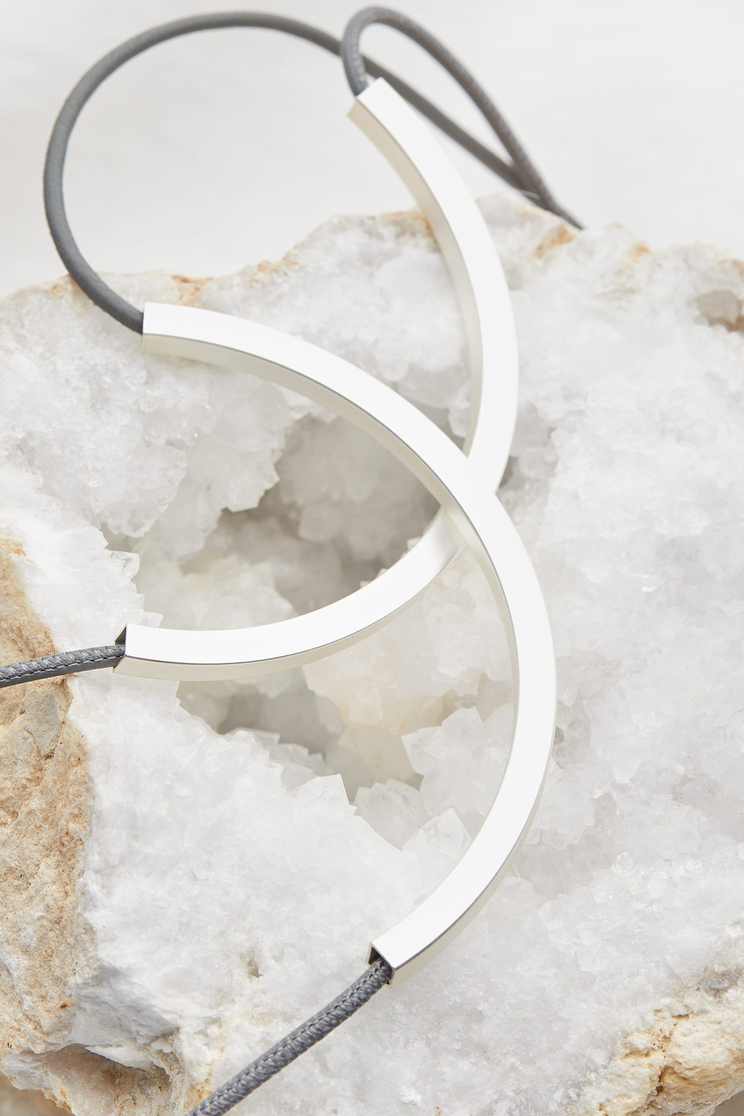 A Double Loop Necklace on a rock, showcasing exquisite jewellery.