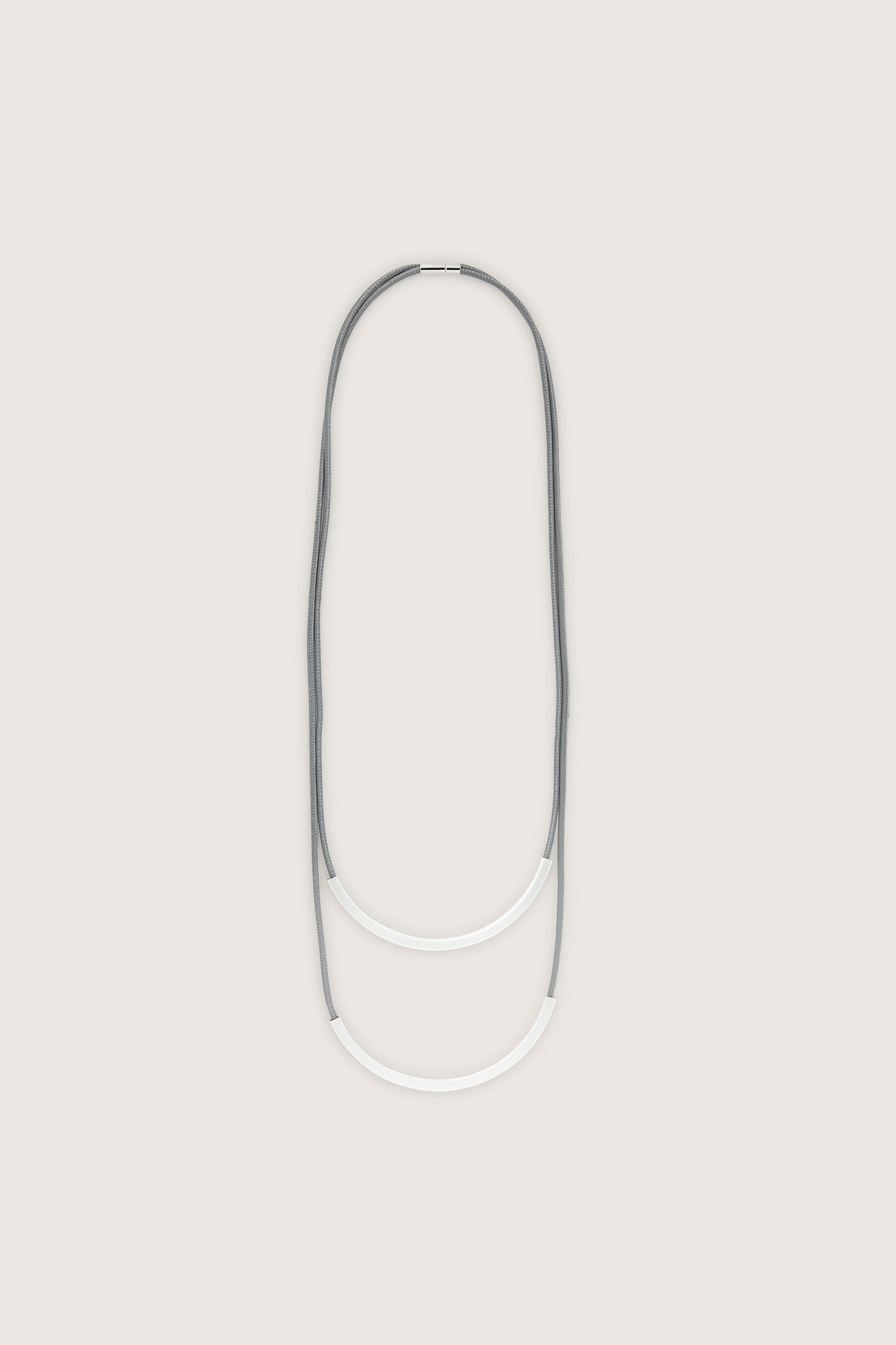 A grey and white Double Loop Necklace on a white background.