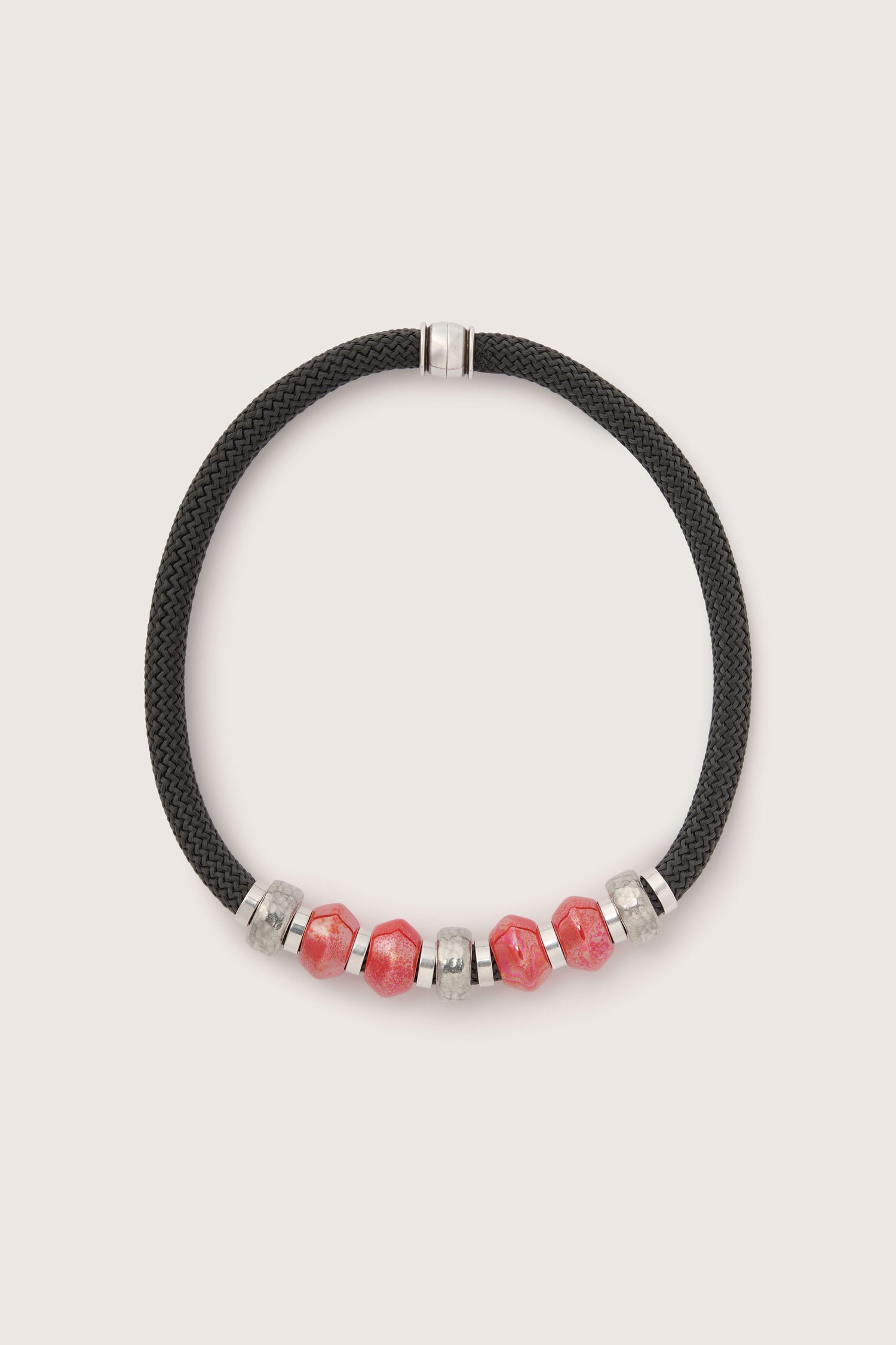 A Coral Bead Cord Necklace, showcasing a contemporary colour scheme, clasped with a metallic fastener.