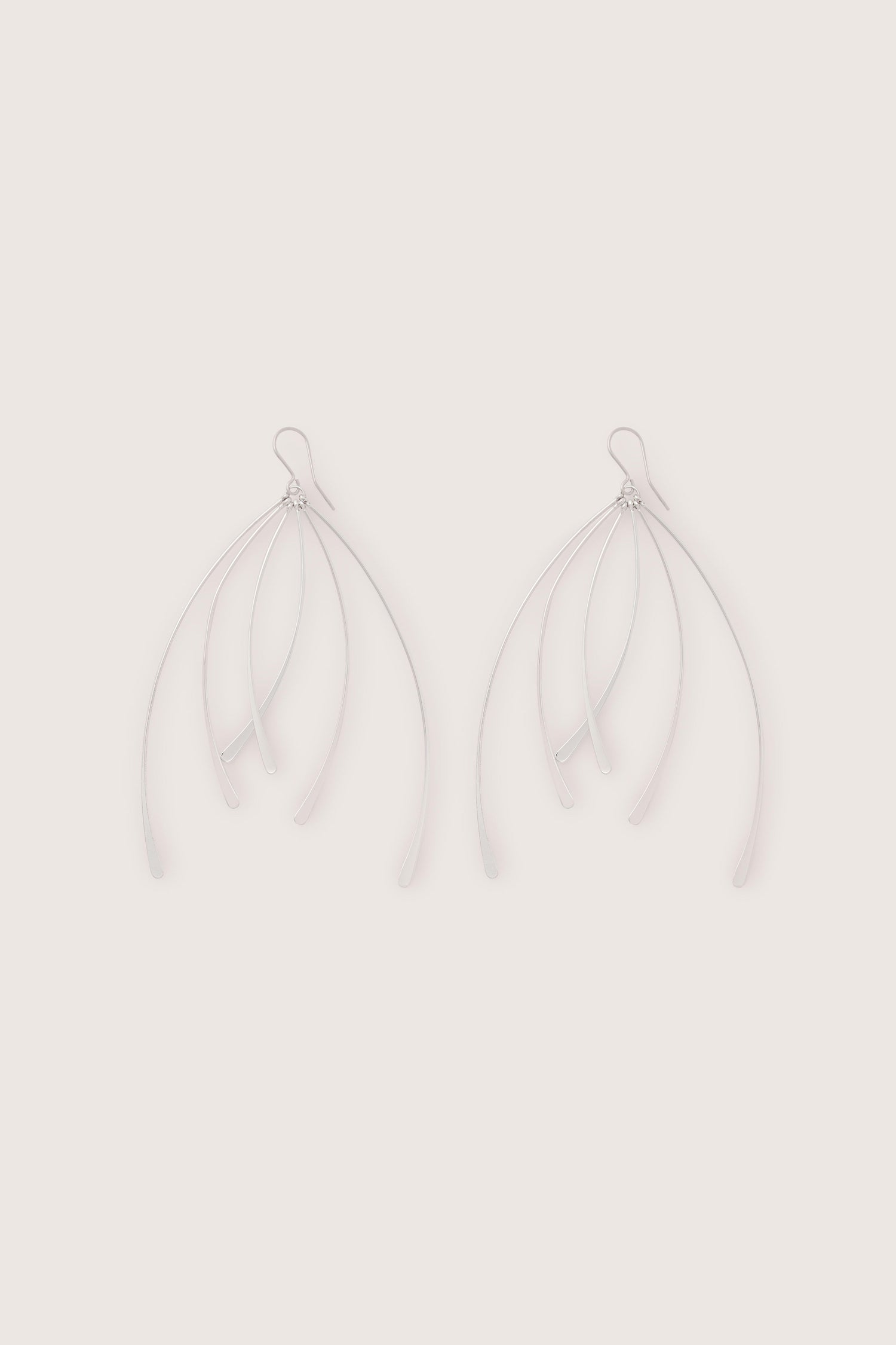 Introducing the Arc Silver Earrings: minimalist silver drop earrings with multiple curved strands branching out from a central point, epitomizing luxury.