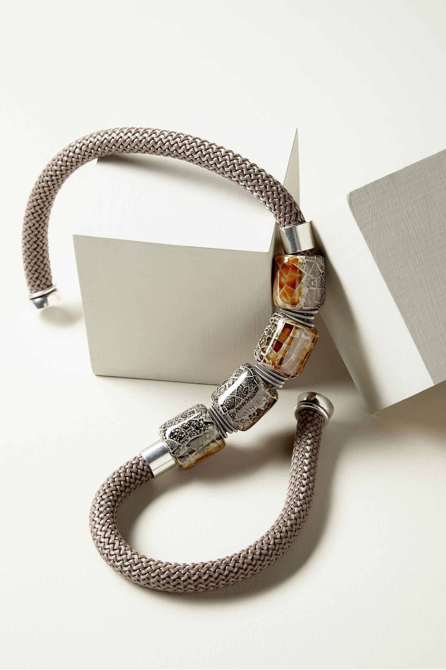 A Ceramic Bead Cord Necklace with ceramic beads on a white surface.