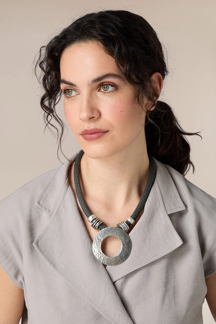 A woman wearing a bold Ornate necklace with a modern flair.