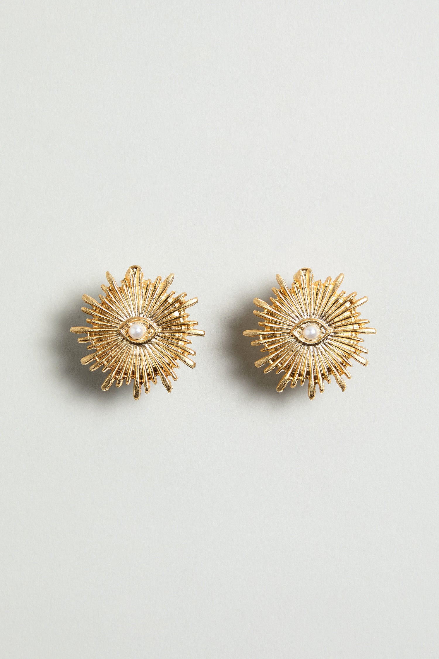 Gold Plated Luna Pearl Earrings featuring a sunburst design with a delicate pearl center, shown on a plain light background.