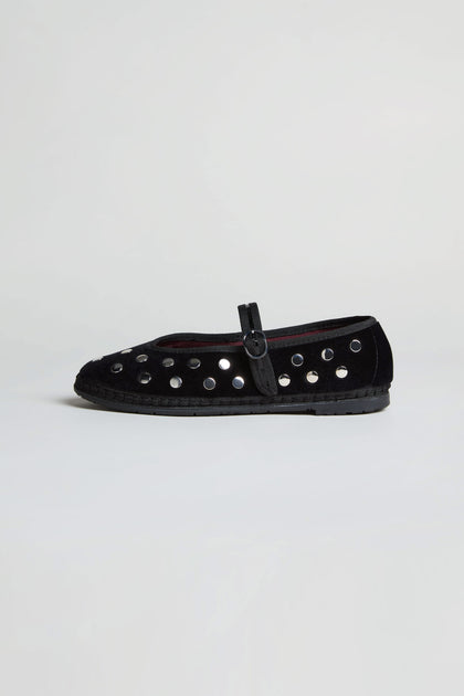 The Studded Mary Jane Velvet Shoes feature black velvet, a buckle strap, and multiple silver eyelets along the sides, exemplifying elegant handmade Spanish footwear against a plain white background.