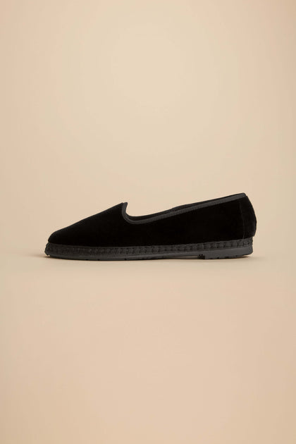 Velvet Slipper Shoes in black velvet with a textured trim above a flat, recycled rubber sole.