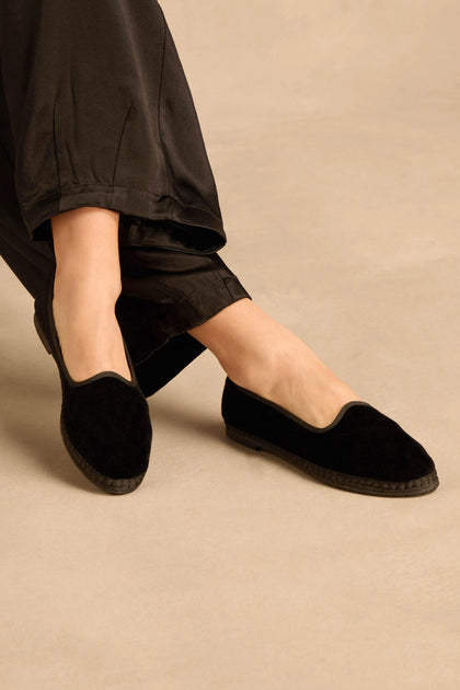 A person wearing handmade Velvet Slipper Shoes featuring jute-trimmed soles.