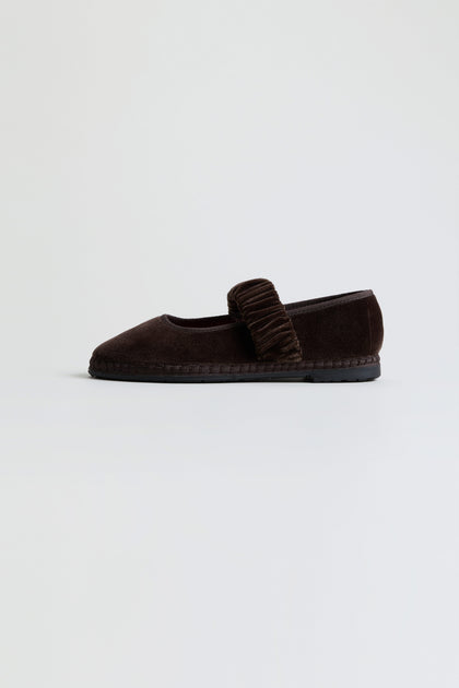 A single Mafalda Truffle Velvet Shoe, handcrafted in Spain with dark brown velvet and featuring a textured strap across the top, displayed on a plain light background.