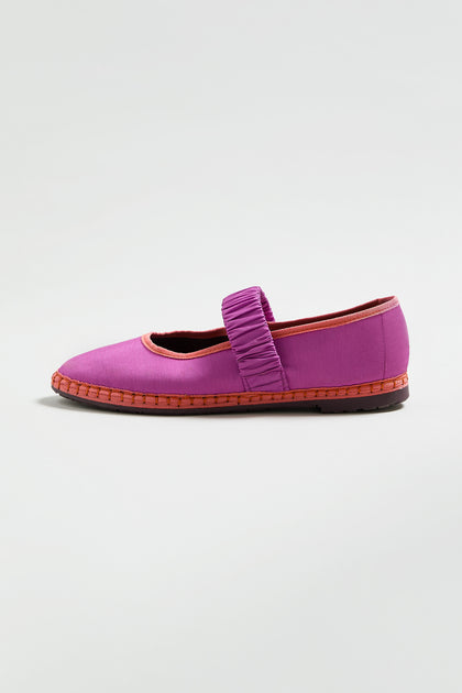 A single purple Mafalda Silk Shoe with a ruched strap and red trim, displayed on a white background. This FLBMAFALDAS online exclusive flat adds a pop of color to any outfit.
