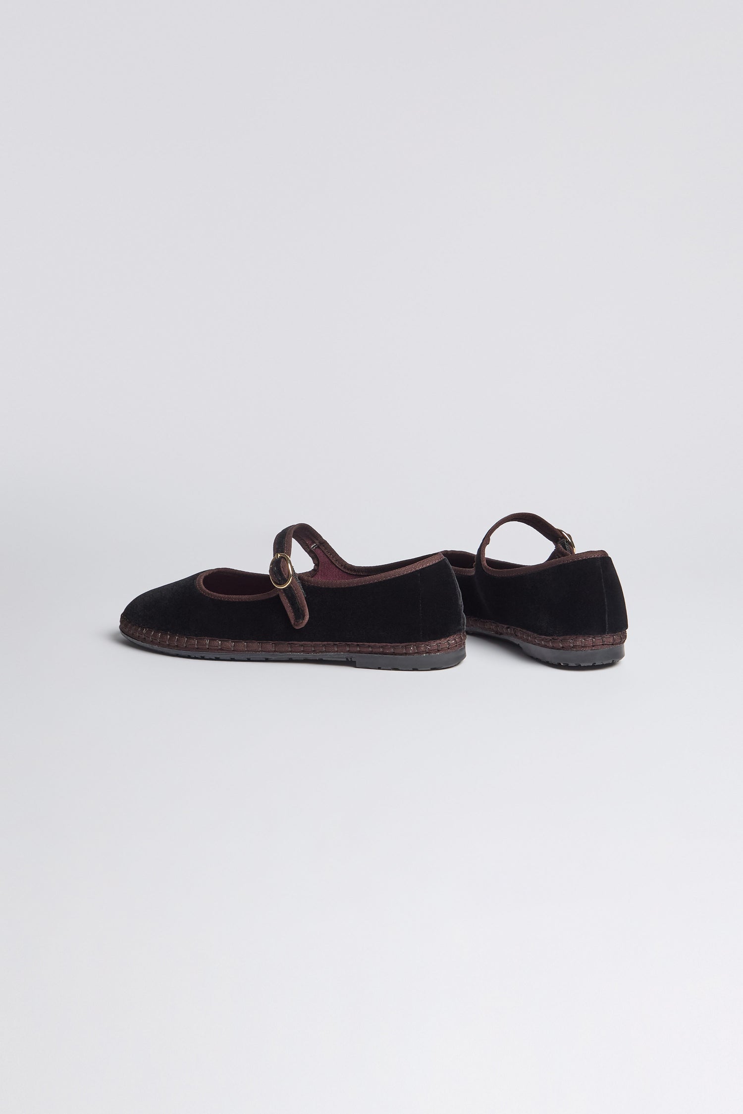 The Black Mary Jane Velvet Shoes feature round toes, buckle straps, and textured soles, expertly crafted with traditional Spanish shoemaking techniques and shown against a plain light background.