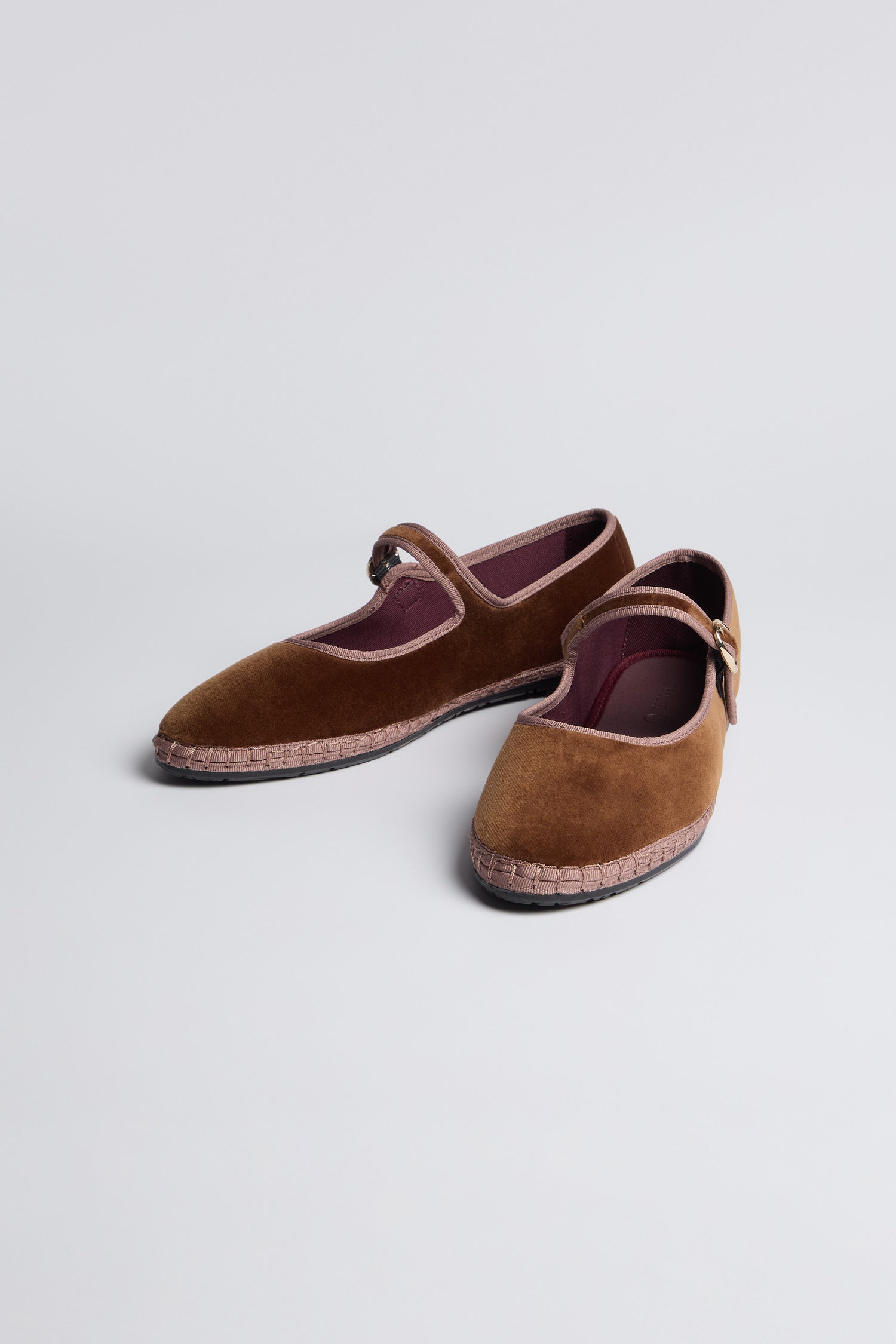 The Brown Mary Jane Velvet Shoes, featuring a single strap and buckle, are displayed on a light grey surface and exude vintage charm and timeless elegance.