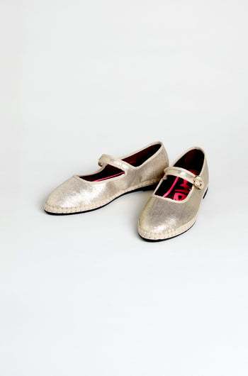The Metallic Mary Jane Shoes feature metallic silver uppers, buckle straps, low heels, and recycled bicycle tyre soles. They are displayed on a plain white background.