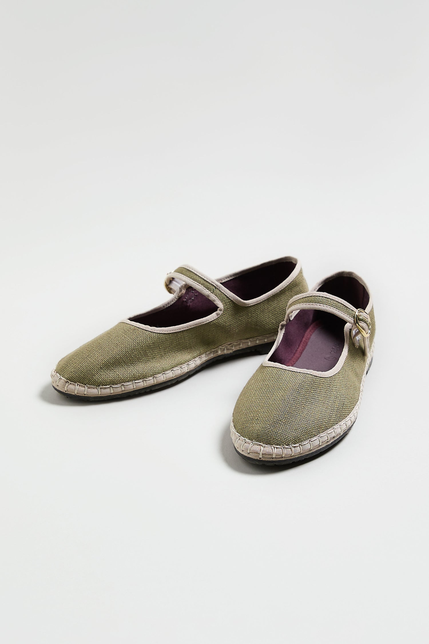 Mary Jane Linen Shoes in olive green feature fabric uppers, white trim, buckle straps, and an organic cotton lining, displayed on a light background.