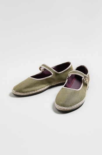 Mary Jane Linen Shoes in olive green feature fabric uppers, white trim, buckle straps, and an organic cotton lining, displayed on a light background.
