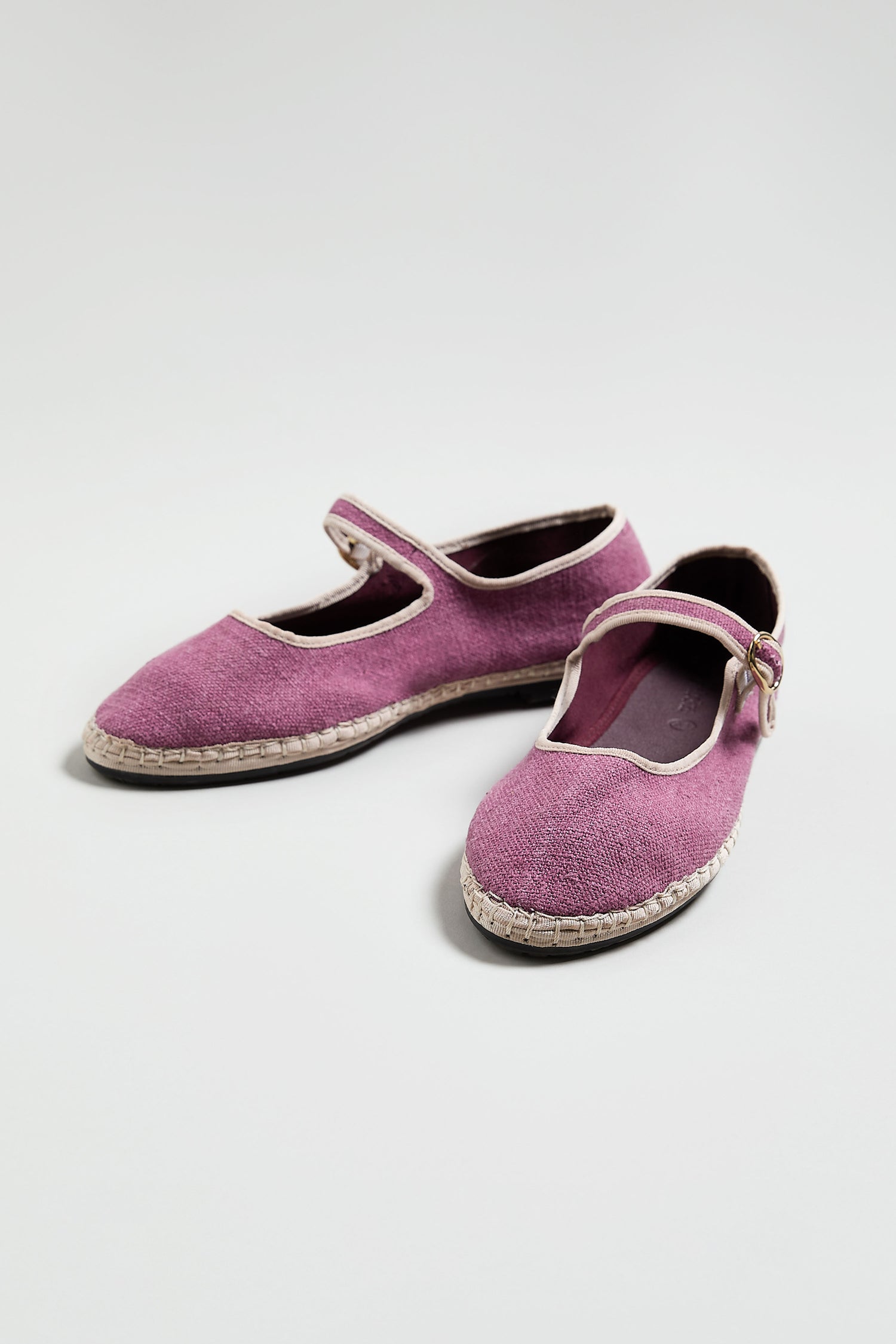 A pair of Mary Jane Linen Shoes in purple, featuring white trim, a buckle strap, and recycled rubber soles, shown on a plain light background.