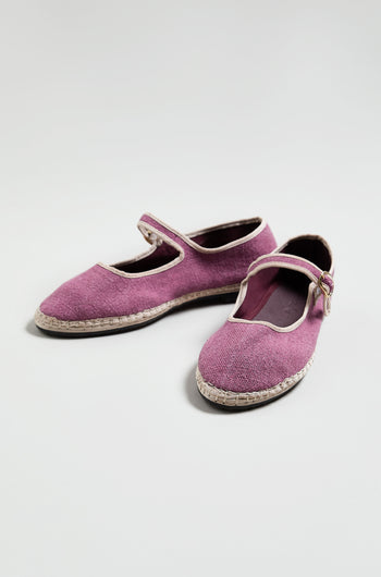 A pair of Mary Jane Linen Shoes in purple, featuring white trim, a buckle strap, and recycled rubber soles, shown on a plain light background.