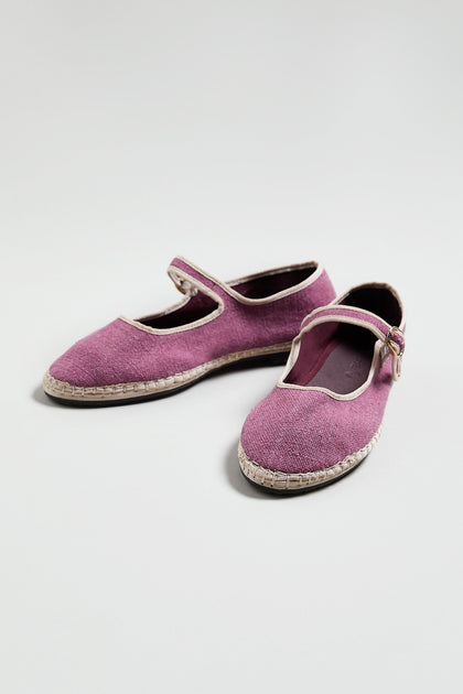 A pair of Mary Jane Linen Shoes in purple, featuring white trim, a buckle strap, and recycled rubber soles, shown on a plain light background.