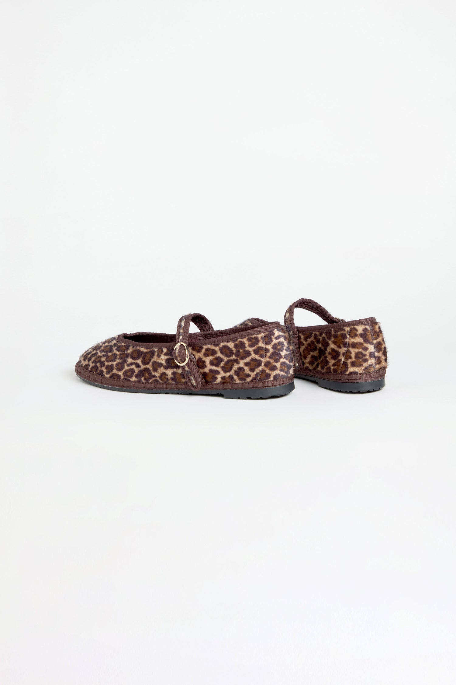 The Cheetah Mary Jane Shoes, featuring a leopard print and recycled bicycle tyre soles, are displayed with one shoe facing forward and the other turned sideways against a plain white background.