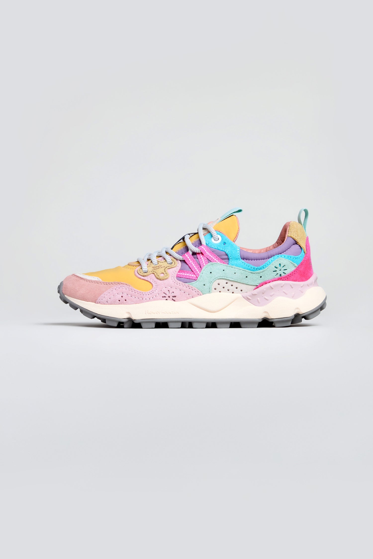The Dijon Yamano 3 Colour Pop Trainers showcase yellow, pink, and turquoise panels with white laces on a chunky white and black sole, adding an outdoor-inspired sneaker style to a plain light background.