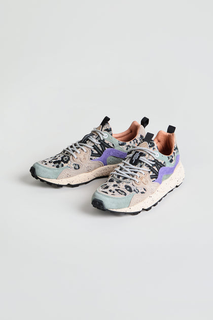 The Yamano 3 Leopard Print Trainers are a pair of trainers featuring pastel green and beige panels, purple accents, speckled chunky soles, and gray laces, displayed on a plain light background.