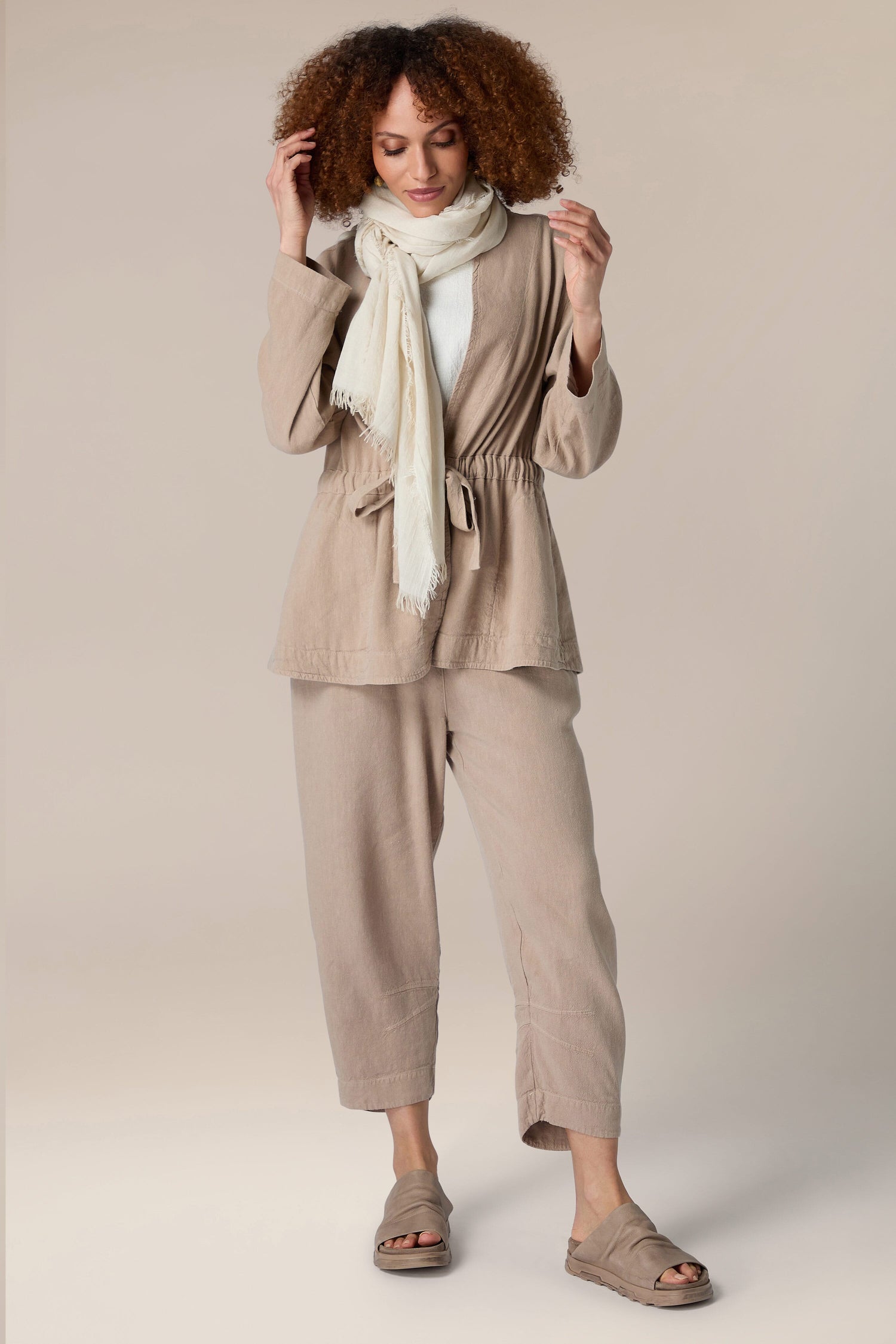 A woman wearing a tan jacket and Soft Fringe Scarf for versatile styling.