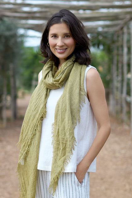 A woman wearing a green Soft Fringe Scarf and striped pants, style FR623297.