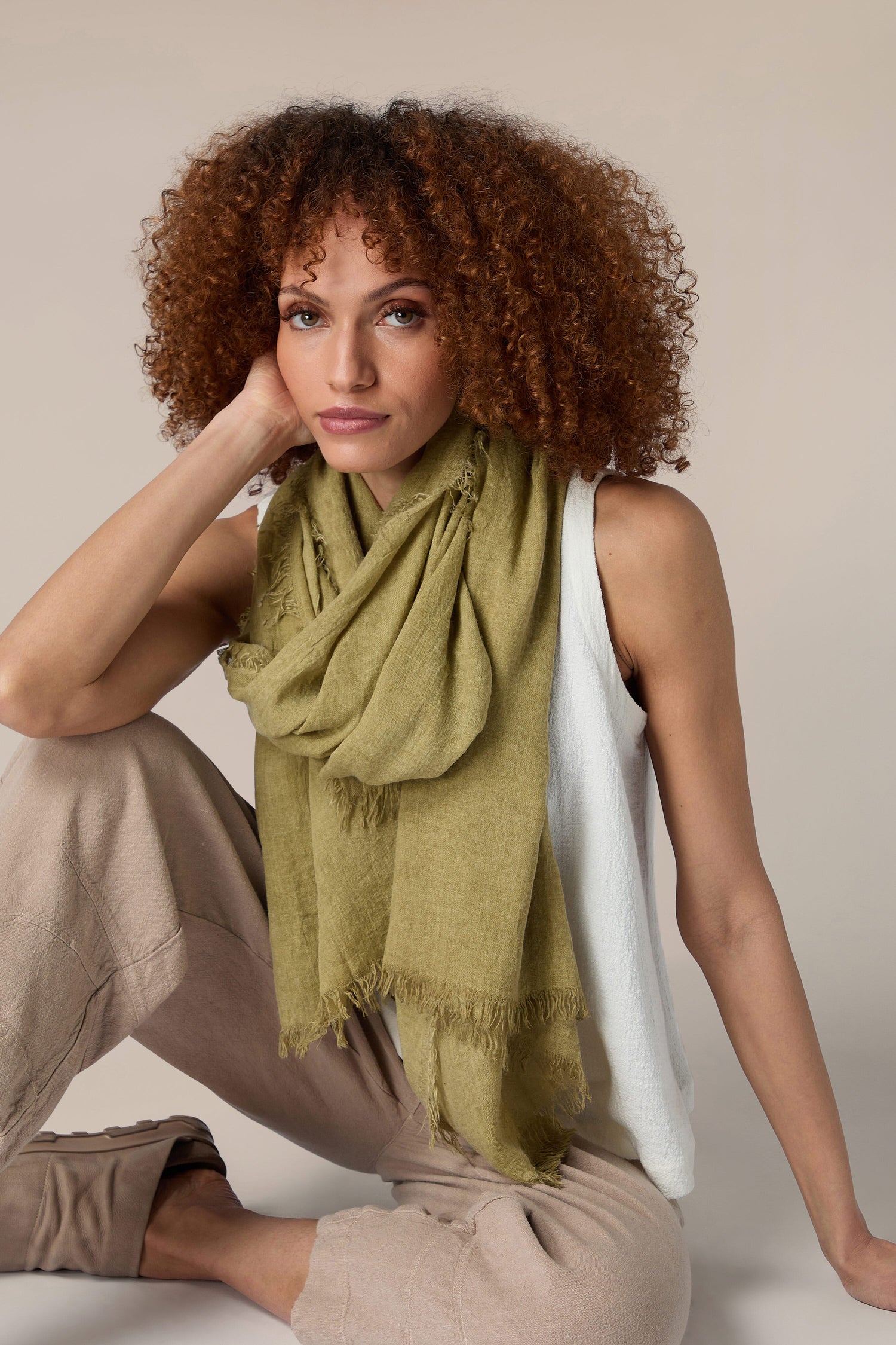 A woman wearing a Soft Fringe Scarf and tan pants.