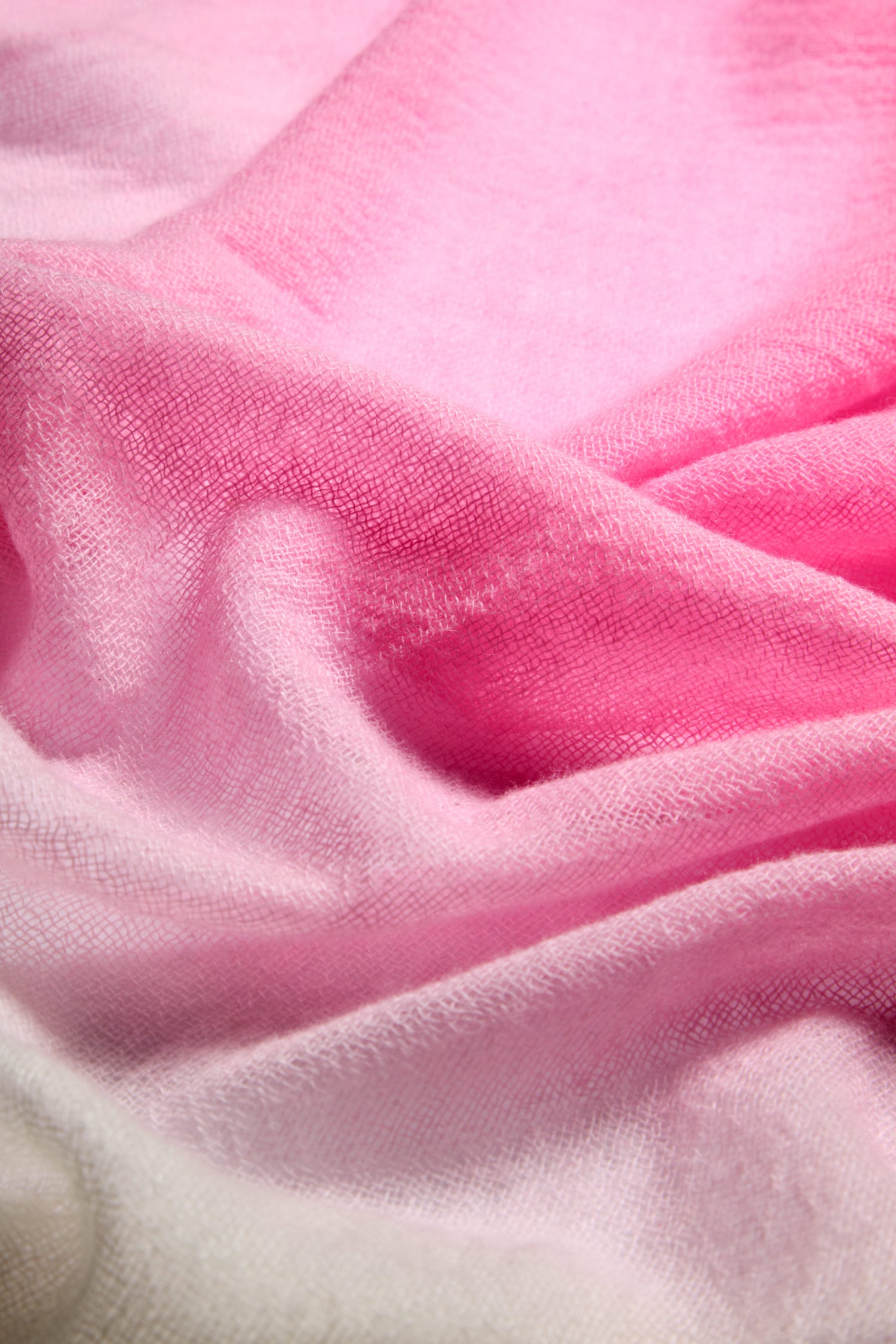 Close-up of a luxurious blend, showcasing the Ombre Wool Scarf in stunning gradient shades of pink, seamlessly transitioning from light to dark.