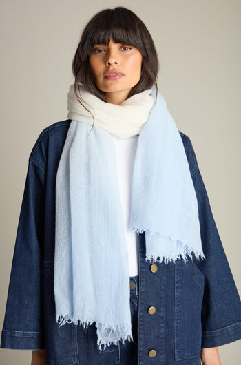 A person with long, dark hair wearing a denim jacket, white shirt, and a large Ombre Wool Scarf (Product Name: Ombre Wool Scarf) stands against a plain background.