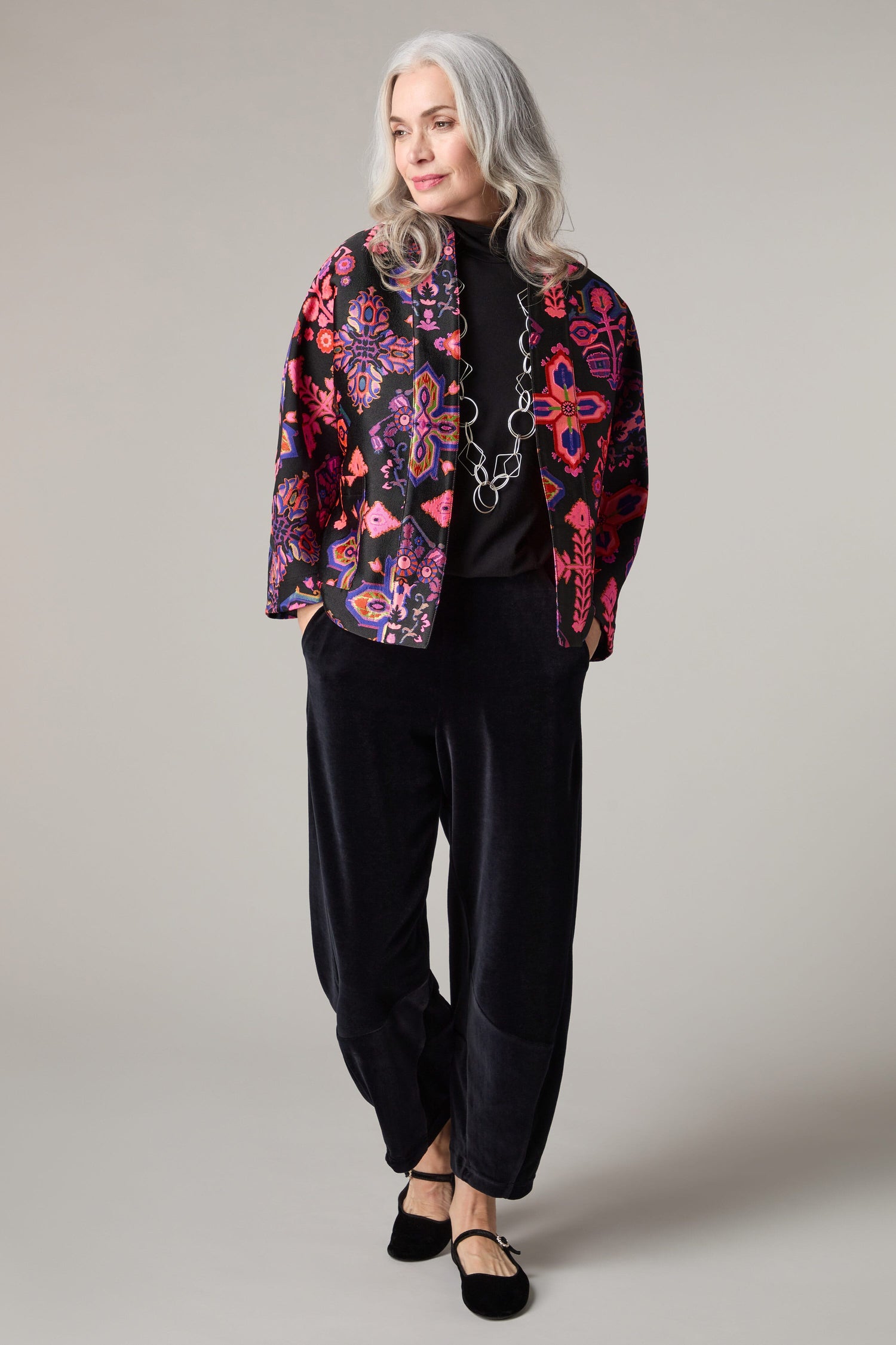 A woman wearing a Jacquard Aztec Floral jacket in a black silhouette.