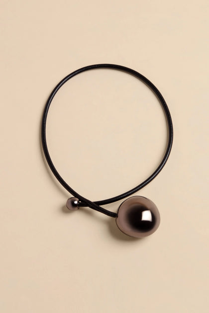 Handmade Charcoal Ceramic Bead Necklace featuring a black leather cord with one large and one small metallic spherical bead.
