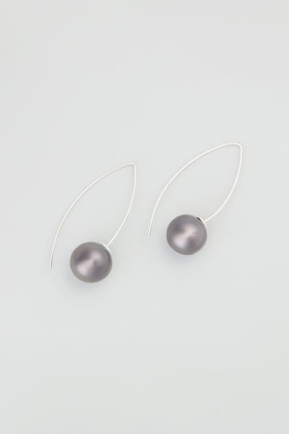 Charcoal Handmade Ceramic Bead Earrings feature artisan silver wire and round, dark gray ceramic beads, capturing the elegance of charcoal ceramics, beautifully displayed against a plain light background.