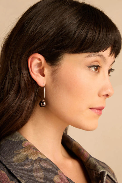 Handmade Charcoal Ceramic Bead Earrings featuring a single charcoal ceramic bead on a curved silver wire hook.
