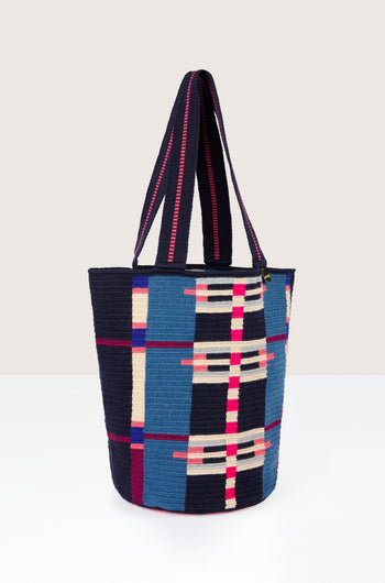 A Handcrafted Cala Tote Bag featuring blue and multicolored geometric patterns, with two handles, set against a neutral background.