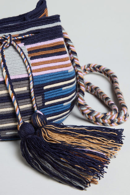 The Handcrafted Crossbody Tassel Bag features multicolored horizontal stripes, a twisted cord strap, and navy and gold tassels—perfect for adding vibrant boho style to any look.