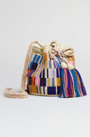 The Hand Crocheted Wayuu Crossbody Bag features a multicoloured geometric design, braided shoulder strap, and large tassel, displayed on a plain white background.