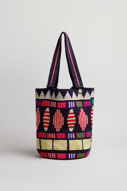 The Hand Crocheted Cala Geometric Tote Bag features vibrant Colombian-inspired patterns and sturdy dual handles, showcased against a plain light background.