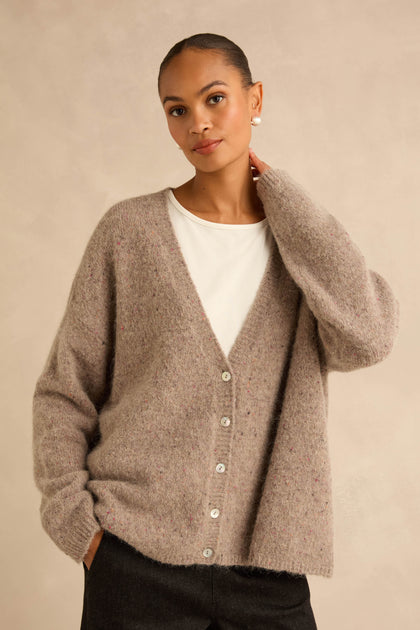 A person wearing a Taupe Alpaca Blend Cropped Cardi over a white top.