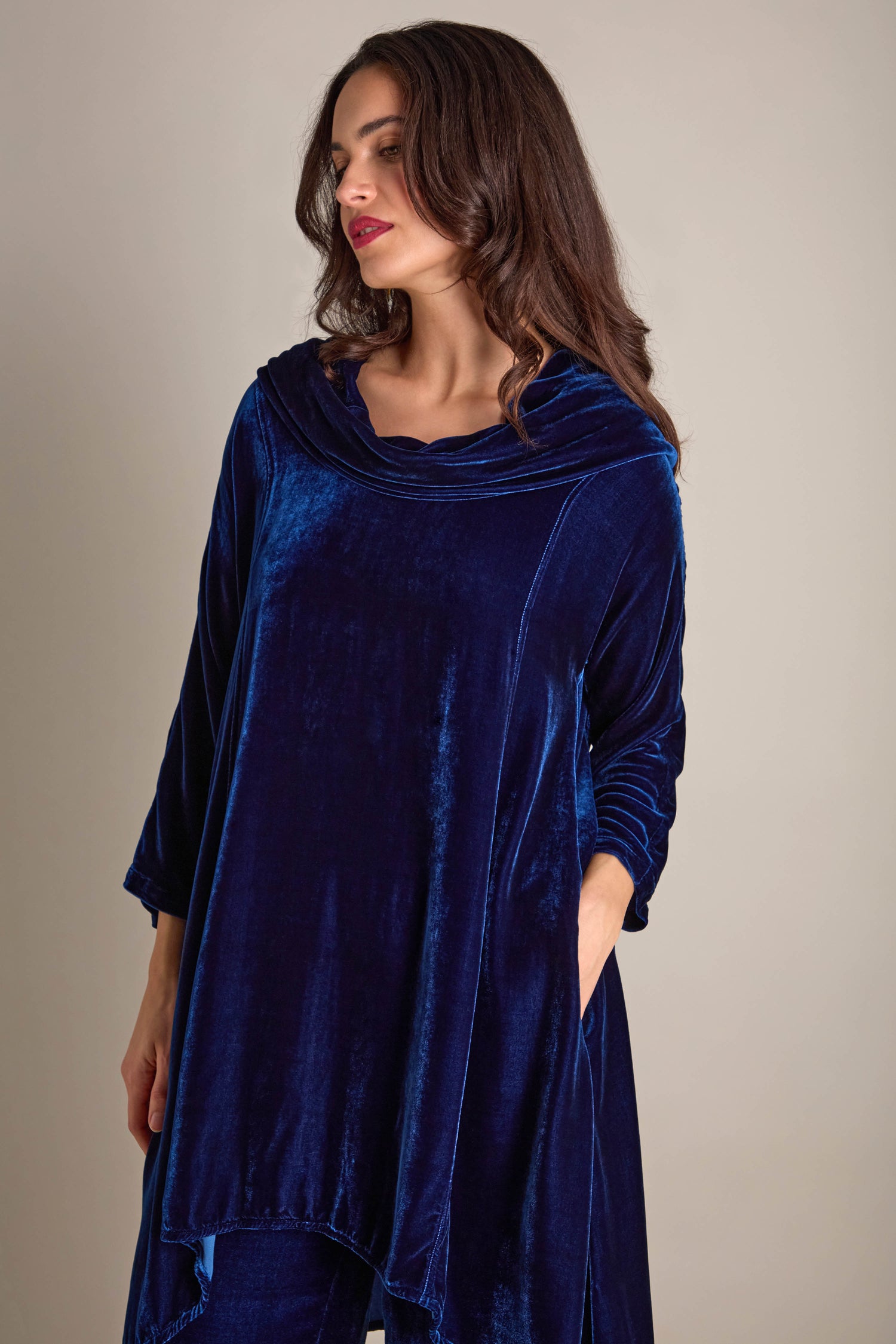 A woman in a luxurious Cowl Silk Velvet Dress stands elegantly against a neutral background.