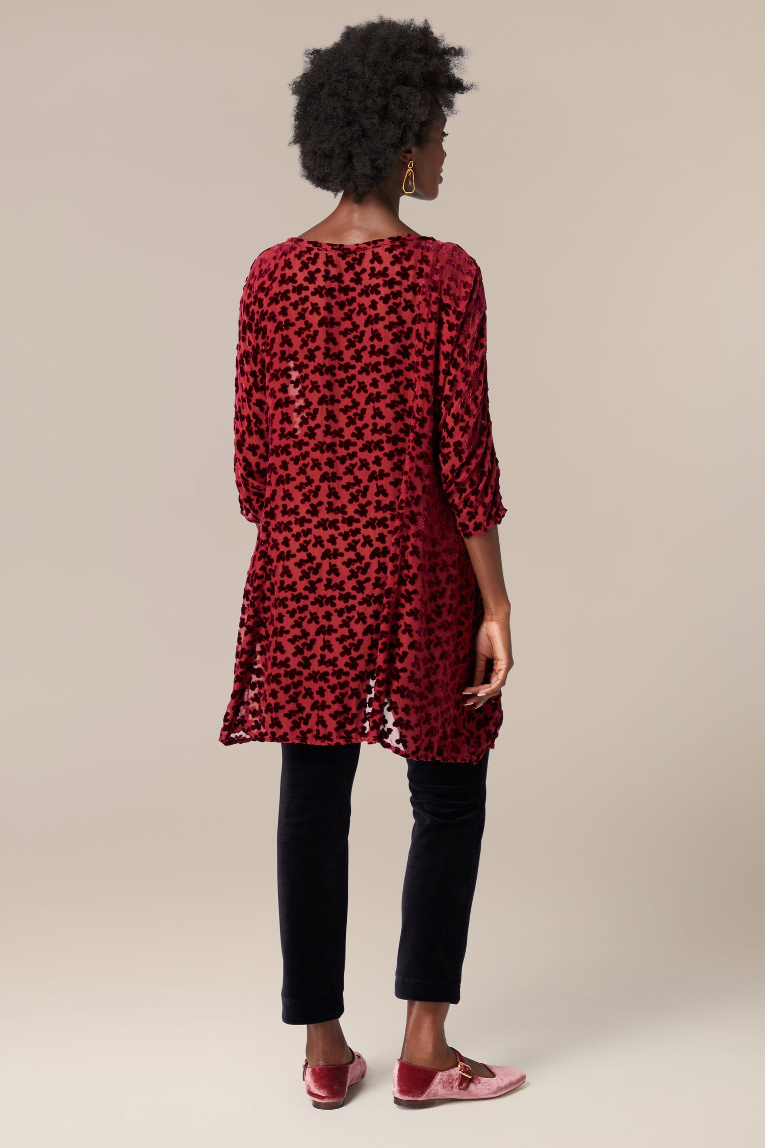 The back view of a woman wearing a Devore Tunic.